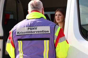 Mitarbeiter der PSNV mit Patientin im Einsatzwagen